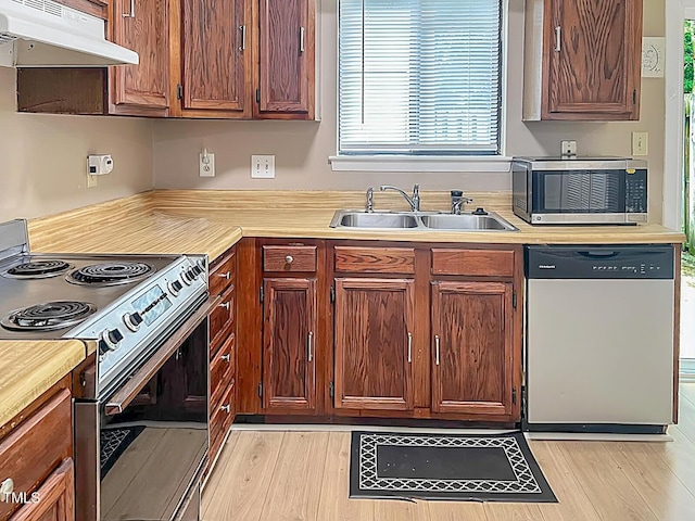5810 Shady Grove Cir, Raleigh, NC 27609 - kitchen featuring appliances with stainless steel finishes, under cabinet range hood, light countertops, and light wood-style floors
