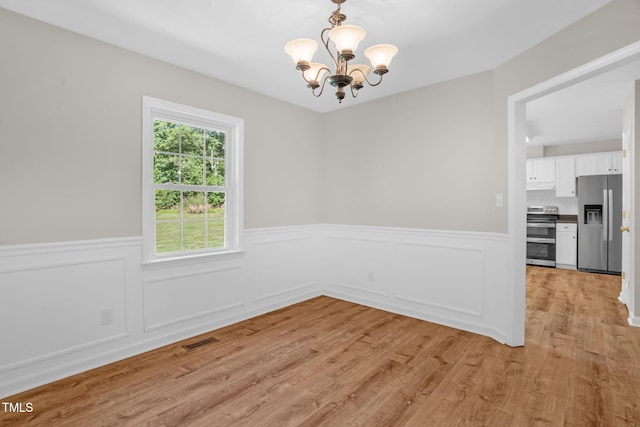514 Lipscomb Grove Church Rd, Hillsborough, NC 27278 - unfurnished dining area with a chandelier, wainscoting, and light wood-style floors