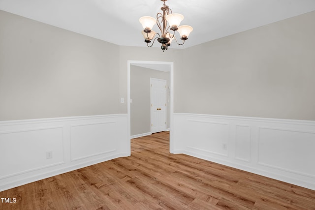 514 Lipscomb Grove Church Rd, Hillsborough, NC 27278 - unfurnished dining area with a chandelier, wainscoting, light wood-style flooring, and a decorative wall