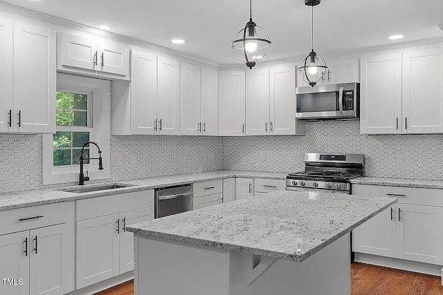 2609 Elmhurst Cir, Raleigh, NC 27610 - kitchen featuring appliances with stainless steel finishes, a center island, white cabinetry, hanging light fixtures, and dark wood-style flooring