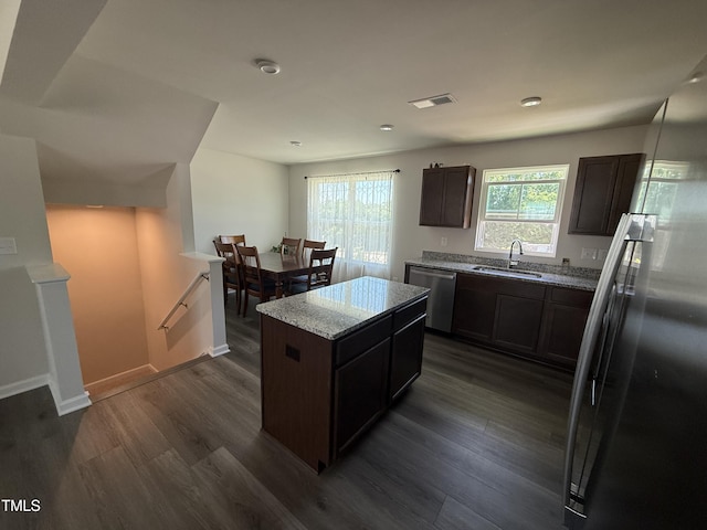 4500 Black Drum Dr, Raleigh, NC 27616 - kitchen with appliances with stainless steel finishes, dark wood-type flooring, light stone countertops, a center island, and dark brown cabinets