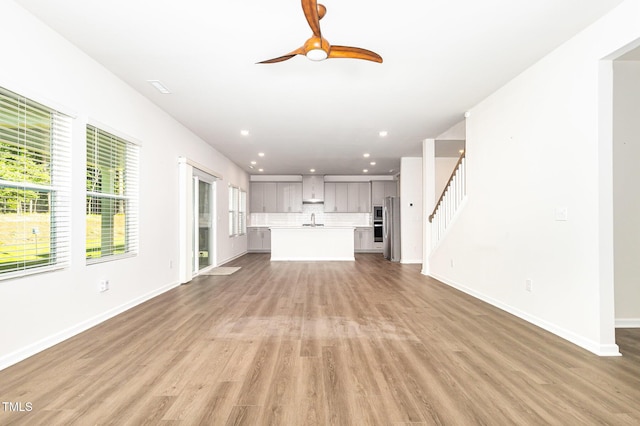 1113 Umstead Grove Way, Durham, NC 27712 - unfurnished living room featuring a ceiling fan, light wood finished floors, recessed lighting, and stairway