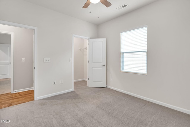 4102 Catfish Way, Durham, NC 27703 - unfurnished bedroom featuring carpet floors, a spacious closet, a closet, and a ceiling fan