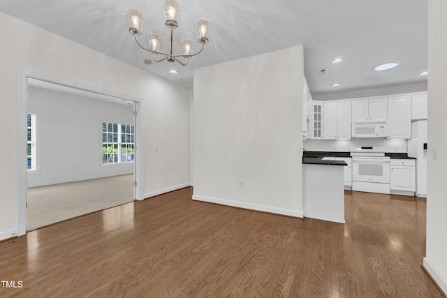 4622 Ludwell Branch Ct, Raleigh, NC 27612 - kitchen featuring white appliances, a chandelier, dark countertops, dark wood-style floors, and white cabinetry