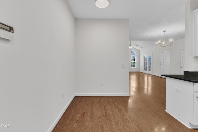 4622 Ludwell Branch Ct, Raleigh, NC 27612 - kitchen featuring white cabinets, a chandelier, wood finished floors, dark countertops, and lofted ceiling