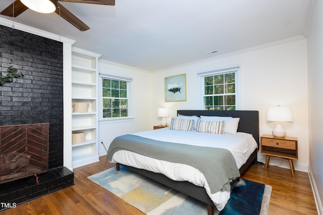256 Marilyn Cir, Cary, NC 27513 - bedroom featuring wood finished floors, crown molding, ceiling fan, and a brick fireplace
