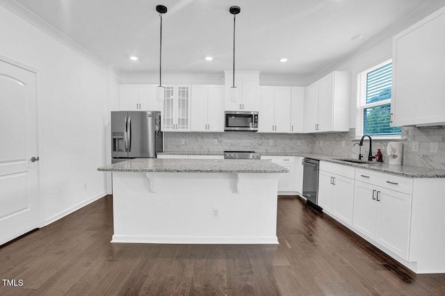 1505 Willow Landing Way, Willow Springs, NC 27592 - kitchen featuring appliances with stainless steel finishes, a kitchen island, tasteful backsplash, light stone counters, and dark wood finished floors