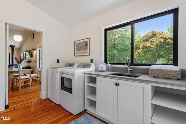 3213 Mid Pines Rd, Raleigh, NC 27606 - washroom with washer and clothes dryer, light wood-type flooring, and cabinet space