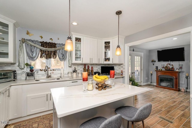 810 Grovemont Rd, Raleigh, NC 27603 - kitchen featuring tasteful backsplash, a kitchen breakfast bar, white cabinets, decorative light fixtures, and recessed lighting