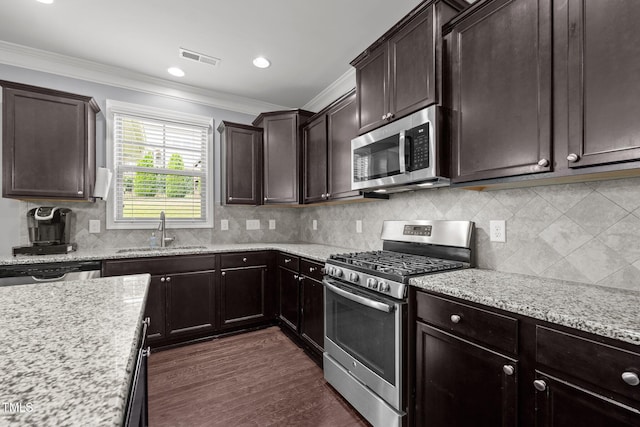 184 Elgin Ct, Burlington, NC 27215 - kitchen with stainless steel appliances, crown molding, dark brown cabinetry, light stone counters, and tasteful backsplash