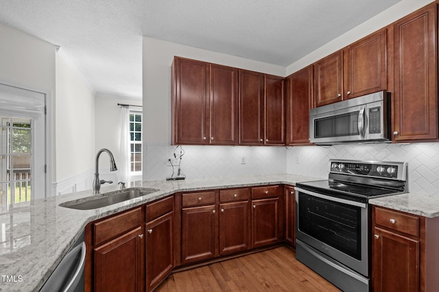 110 Bonhill Ct, Apex, NC 27502 - kitchen with stainless steel appliances, light wood finished floors, light stone counters, decorative backsplash, and crown molding