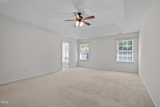 110 Bonhill Ct, Apex, NC 27502 - empty room featuring a tray ceiling, light colored carpet, healthy amount of natural light, and ceiling fan