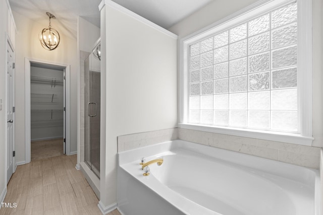 110 Bonhill Ct, Apex, NC 27502 - bathroom with a garden tub, a stall shower, a walk in closet, and a chandelier