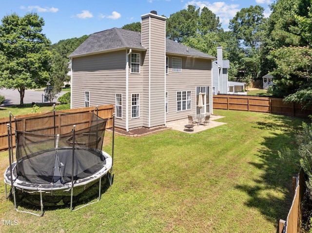 110 Bonhill Ct, Apex, NC 27502 - rear view of house featuring a trampoline, a patio, a fenced backyard, a chimney, and a shingled roof