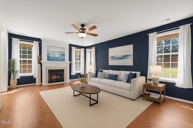 110 Bonhill Ct, Apex, NC 27502 - living room featuring wood-type flooring, ceiling fan, and a fireplace with flush hearth