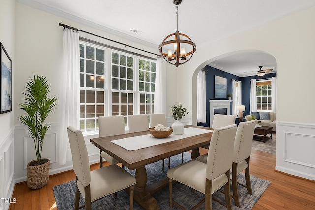 110 Bonhill Ct, Apex, NC 27502 - dining room featuring arched walkways, ornamental molding, wainscoting, wood finished floors, and a decorative wall
