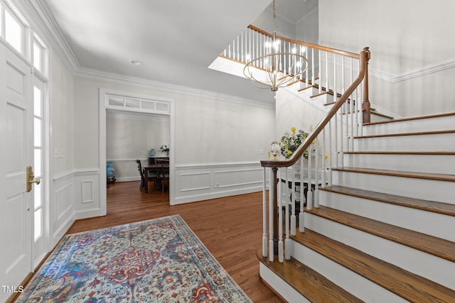 1105 Tazwell Pl, Raleigh, NC 27612 - foyer with a chandelier, stairway, ornamental molding, wood finished floors, and a decorative wall