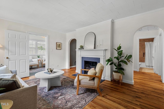 2504 State St, Durham, NC 27704 - living area featuring arched walkways, crown molding, wood finished floors, and a brick fireplace