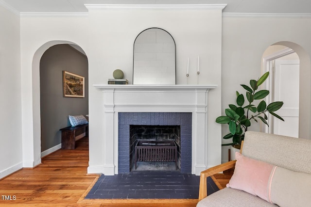 2504 State St, Durham, NC 27704 - detailed view of wood finished floors, crown molding, a fireplace with flush hearth, and arched walkways