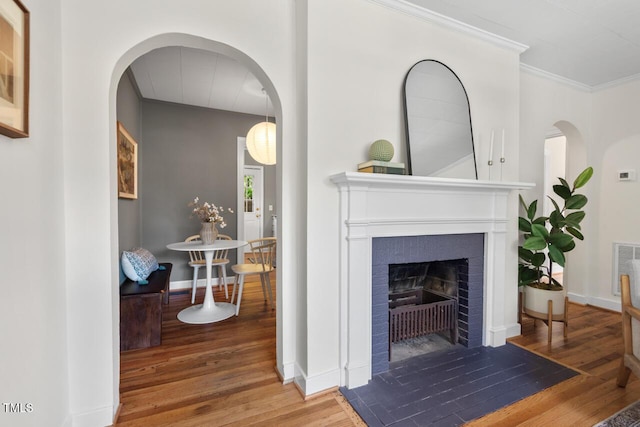 2504 State St, Durham, NC 27704 - living room with wood finished floors, a fireplace, ornamental molding, and arched walkways
