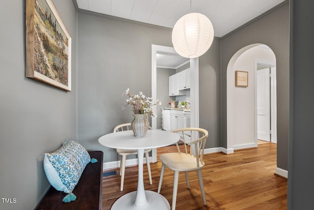 2504 State St, Durham, NC 27704 - dining area featuring crown molding, arched walkways, and light wood-style flooring
