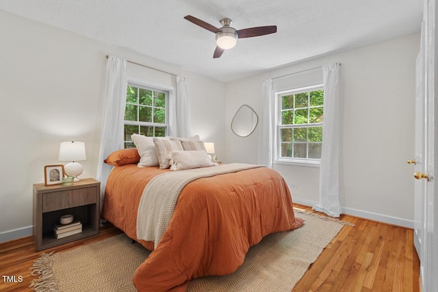 2504 State St, Durham, NC 27704 - bedroom featuring multiple windows, light wood-style floors, and ceiling fan