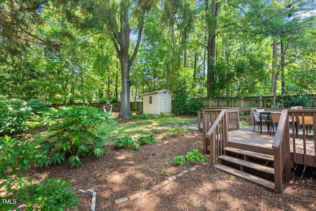 2504 State St, Durham, NC 27704 - fenced backyard with a shed, a wooden deck, outdoor dining space, and view of wooded area
