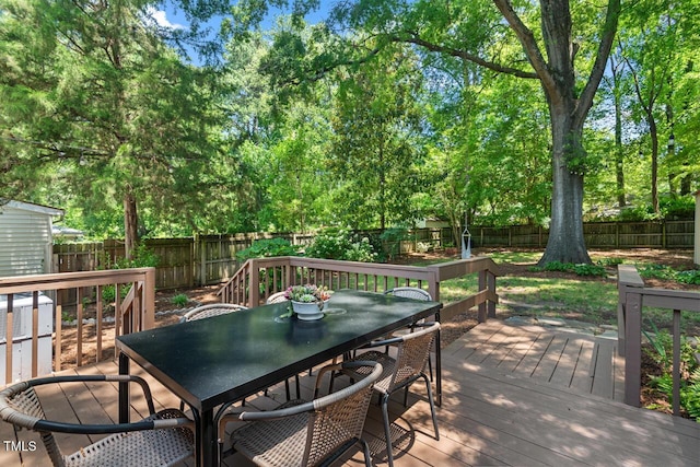 2504 State St, Durham, NC 27704 - wooden deck with outdoor dining space, a fenced backyard, and view of wooded area