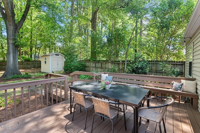 2504 State St, Durham, NC 27704 - wooden terrace featuring outdoor dining area, a fenced backyard, a storage unit, and view of scattered trees
