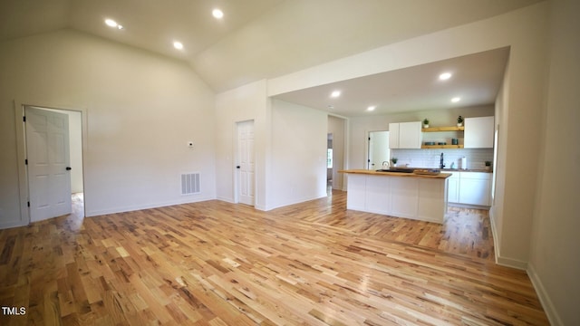 416 Everett St, Burlington, NC 27215 - unfurnished living room with light wood-type flooring, recessed lighting, and lofted ceiling