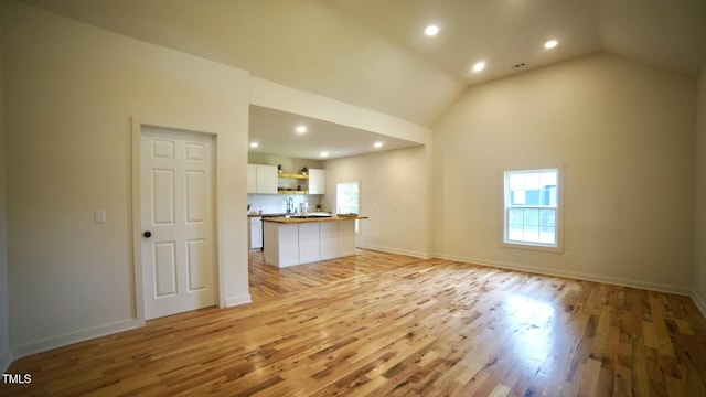 416 Everett St, Burlington, NC 27215 - unfurnished living room with healthy amount of natural light, light wood finished floors, recessed lighting, and high vaulted ceiling