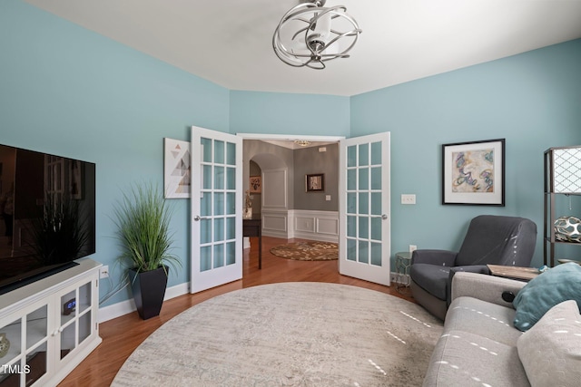621 Aylestone Dr, Cary, NC 27519 - living room featuring french doors, arched walkways, a chandelier, and wood finished floors
