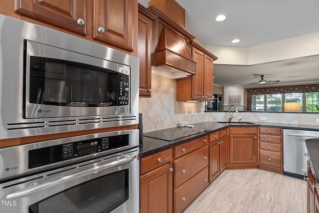 621 Aylestone Dr, Cary, NC 27519 - kitchen with stainless steel appliances, brown cabinetry, decorative backsplash, dark stone counters, and recessed lighting