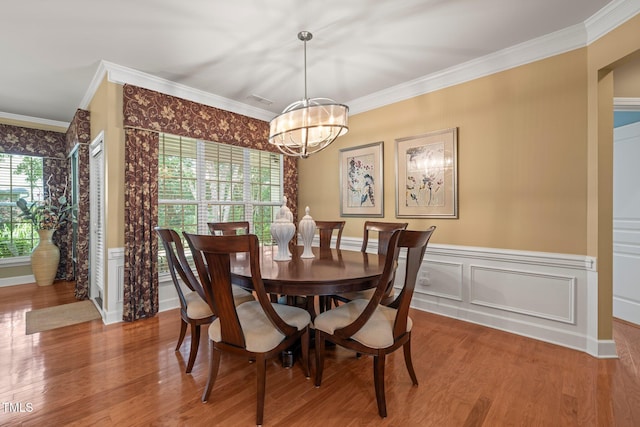 621 Aylestone Dr, Cary, NC 27519 - dining area featuring ornamental molding, a chandelier, wood finished floors, wainscoting, and a decorative wall