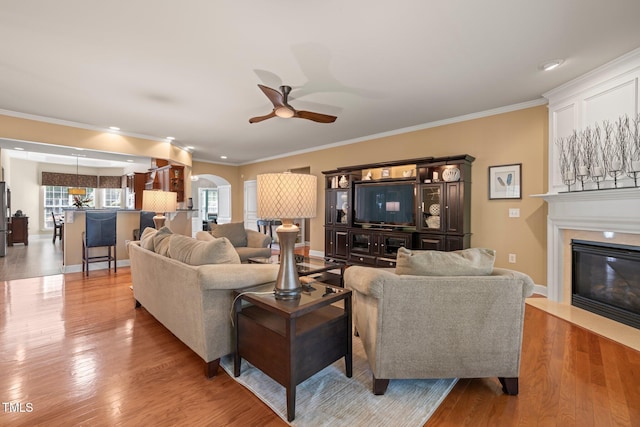621 Aylestone Dr, Cary, NC 27519 - living room with a ceiling fan, a fireplace with flush hearth, arched walkways, crown molding, and wood finished floors