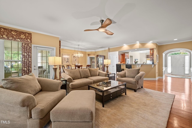 621 Aylestone Dr, Cary, NC 27519 - living room with light wood-style floors, healthy amount of natural light, a chandelier, a ceiling fan, and crown molding