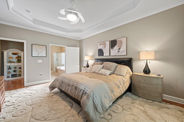 621 Aylestone Dr, Cary, NC 27519 - bedroom featuring a tray ceiling, ornamental molding, ensuite bathroom, ceiling fan, and light wood-style floors