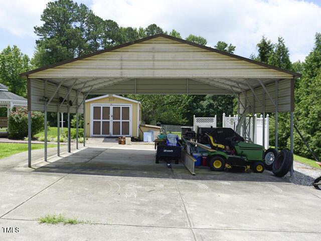 2817 Buckboard Ln, Raleigh, NC 27603 - view of parking with a storage shed, driveway, and a carport