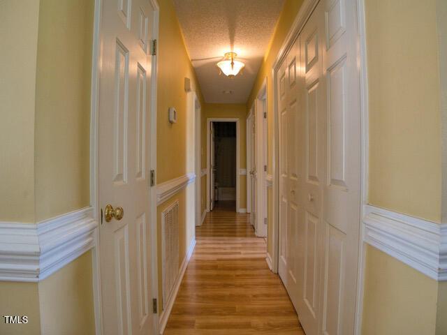 2817 Buckboard Ln, Raleigh, NC 27603 - hall with light wood-style flooring and a wainscoted wall