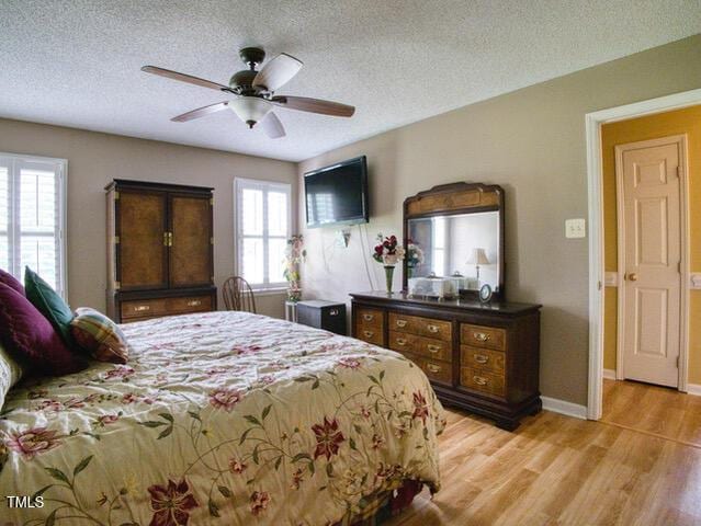 2817 Buckboard Ln, Raleigh, NC 27603 - bedroom featuring light wood-style flooring, a textured ceiling, and ceiling fan