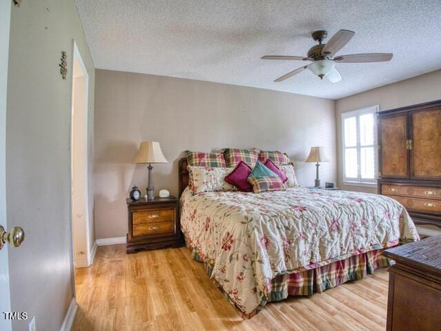 2817 Buckboard Ln, Raleigh, NC 27603 - bedroom featuring a textured ceiling, light wood finished floors, and a ceiling fan