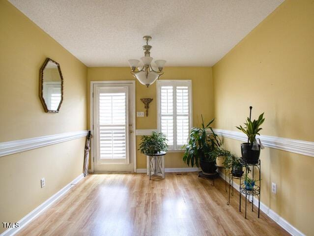 2817 Buckboard Ln, Raleigh, NC 27603 - sitting room featuring a chandelier, wood finished floors, and a textured ceiling