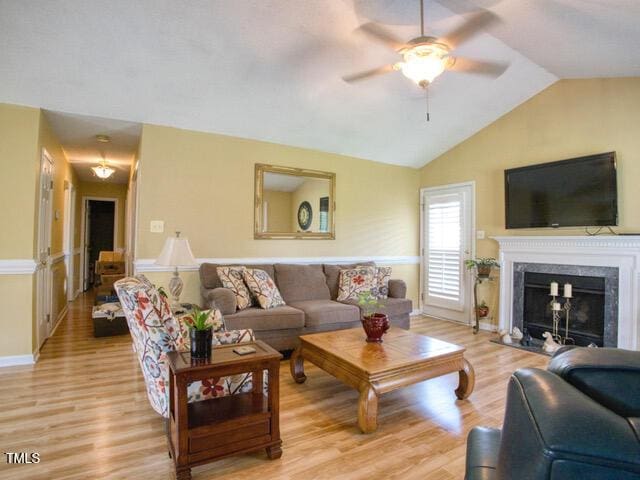 2817 Buckboard Ln, Raleigh, NC 27603 - living room featuring light wood finished floors, ceiling fan, vaulted ceiling, and a fireplace