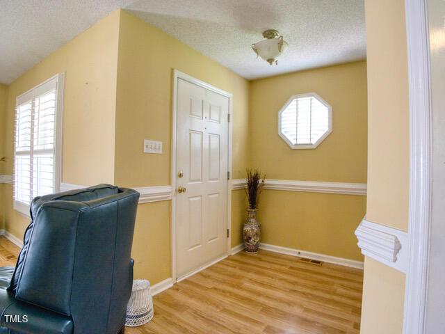 2817 Buckboard Ln, Raleigh, NC 27603 - unfurnished room with a textured ceiling, light wood-style flooring, and healthy amount of natural light
