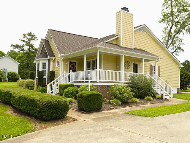 2817 Buckboard Ln, Raleigh, NC 27603 - view of front of home featuring a porch, stairs, a chimney, and a shingled roof