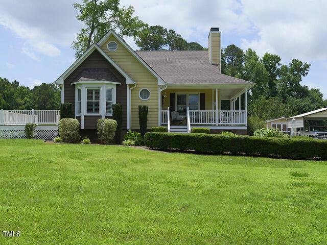 2817 Buckboard Ln, Raleigh, NC 27603 - view of front of house with a chimney, a front yard, and a porch