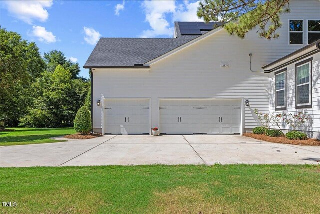 1809 Bowling Rd, Fuquay Varina, NC 27526 - view of home's exterior featuring driveway, a yard, a shingled roof, roof mounted solar panels, and an attached garage