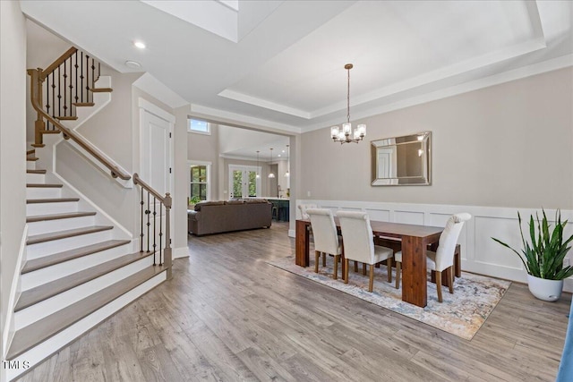 1809 Bowling Rd, Fuquay Varina, NC 27526 - dining area with a raised ceiling, a chandelier, stairs, wood finished floors, and wainscoting
