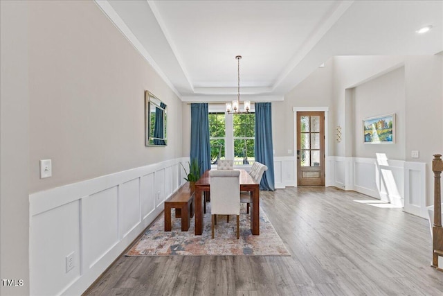 1809 Bowling Rd, Fuquay Varina, NC 27526 - dining room with a chandelier, a tray ceiling, a decorative wall, wood finished floors, and wainscoting