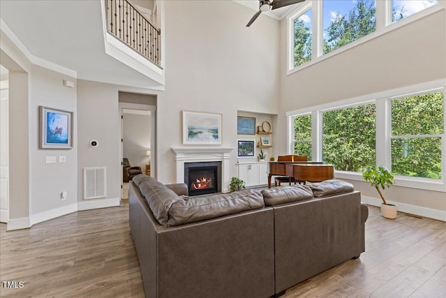 1809 Bowling Rd, Fuquay Varina, NC 27526 - living room with ceiling fan, a high ceiling, a glass covered fireplace, and wood finished floors